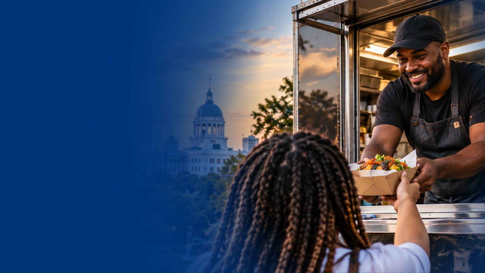 Montgomery food truck owner serving a customer at sunset with the Alabama State Capitol in the background